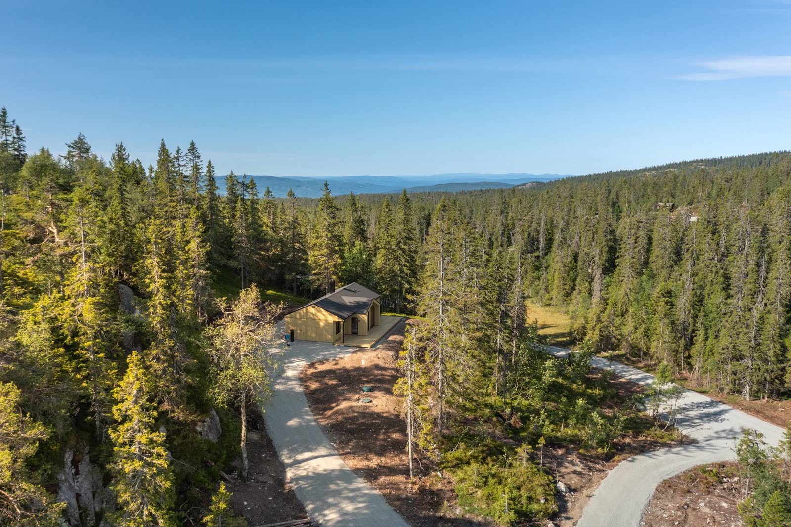Hytte med utsikt over skog og åser